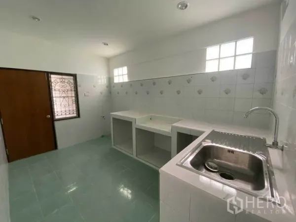 独立式住宅 出租在Huai Khwang, Bangkok - 采光良好的瓷砖厨房，带内置台面和不锈钢水槽。