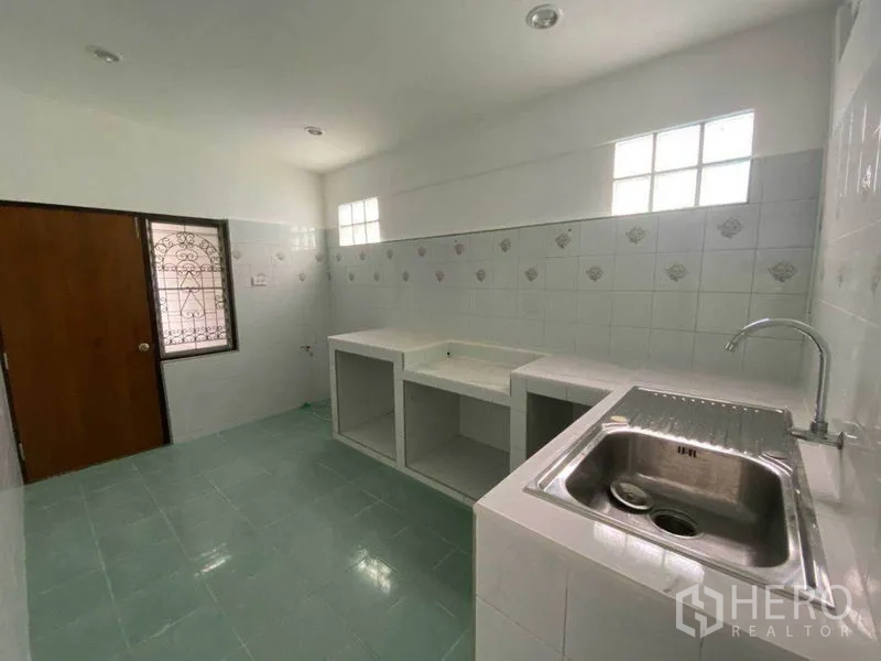 独立式住宅 出租在Huai Khwang, Bangkok - 采光良好的瓷砖厨房，带内置台面和不锈钢水槽。