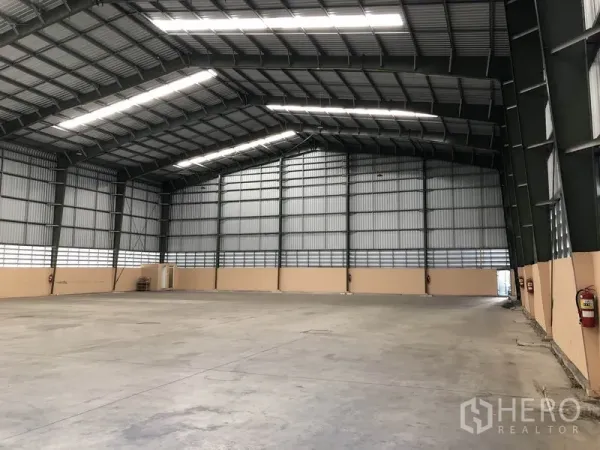 货栈 出租在Pathum Thani - 仓库内部，大跨度无柱空间，高钢梁屋顶、采光带与平整混凝土地面