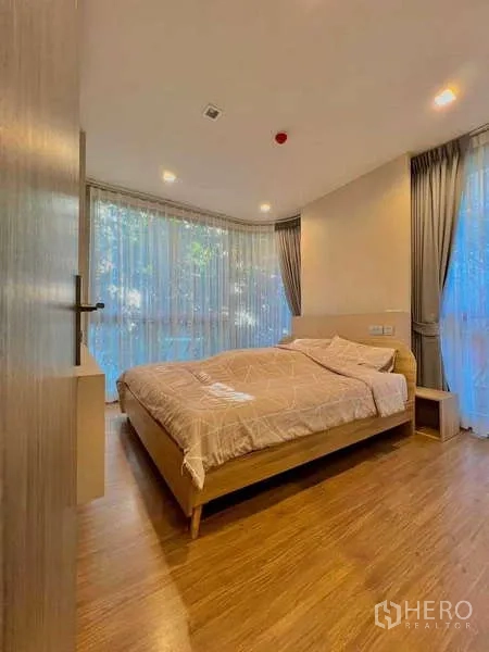 คอนโด ขายในWatthana, Bangkok - ห้องนอนหลักมีหน้าต่างมุมบานใหญ่ ผ้าม่าน และพื้นไม้