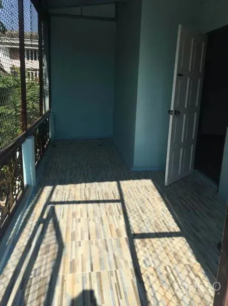 Detached House for rent in Chatuchak, Bangkok - Shaded balcony with tiled floor, mesh screen and an open doorway in a Bangkok house.