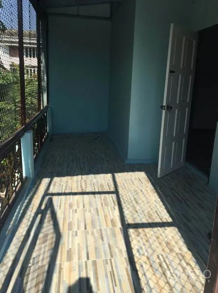 Detached House for rent in Chatuchak, Bangkok - Shaded balcony with tiled floor, mesh screen and an open doorway in a Bangkok house.