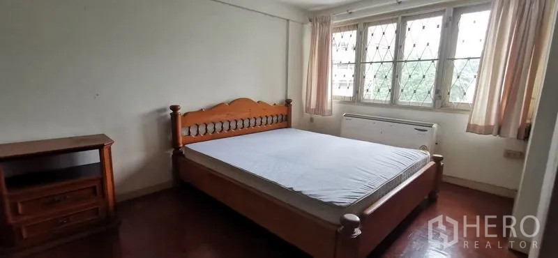 联排别墅 出租在Watthana, Bangkok - 卧室配木床、床头柜与大窗户及防护栏