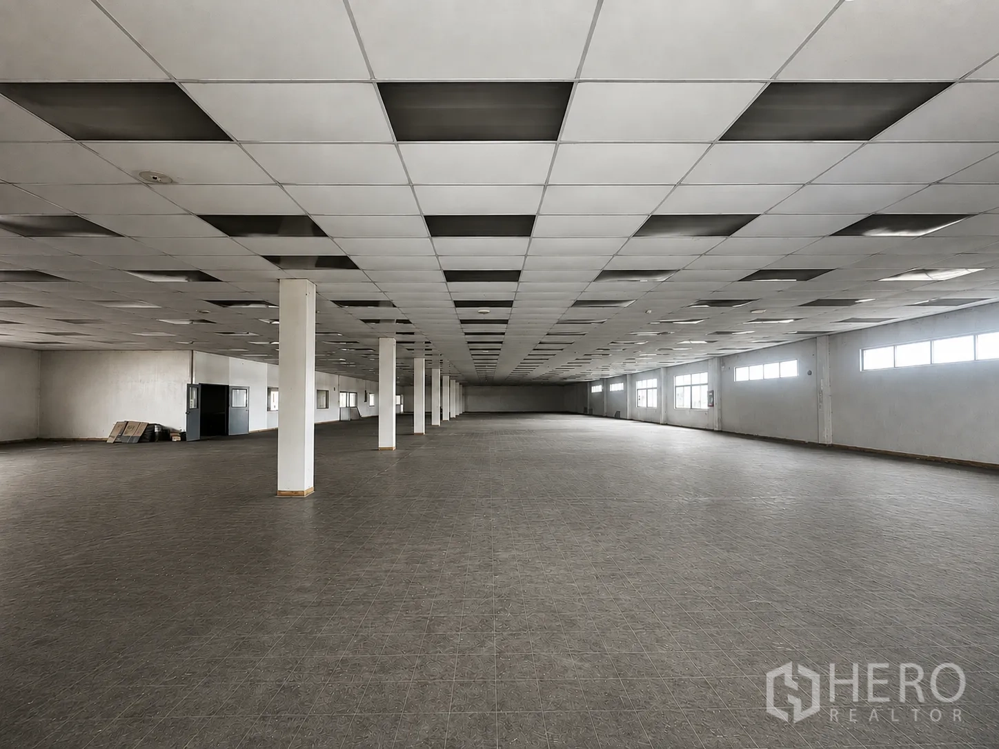 Factory for rent or sale in Wang Noi, Phra Nakhon Si Ayutthaya - Vast open-plan factory floor with tiled flooring, grid ceiling panels, support columns, and side windows.