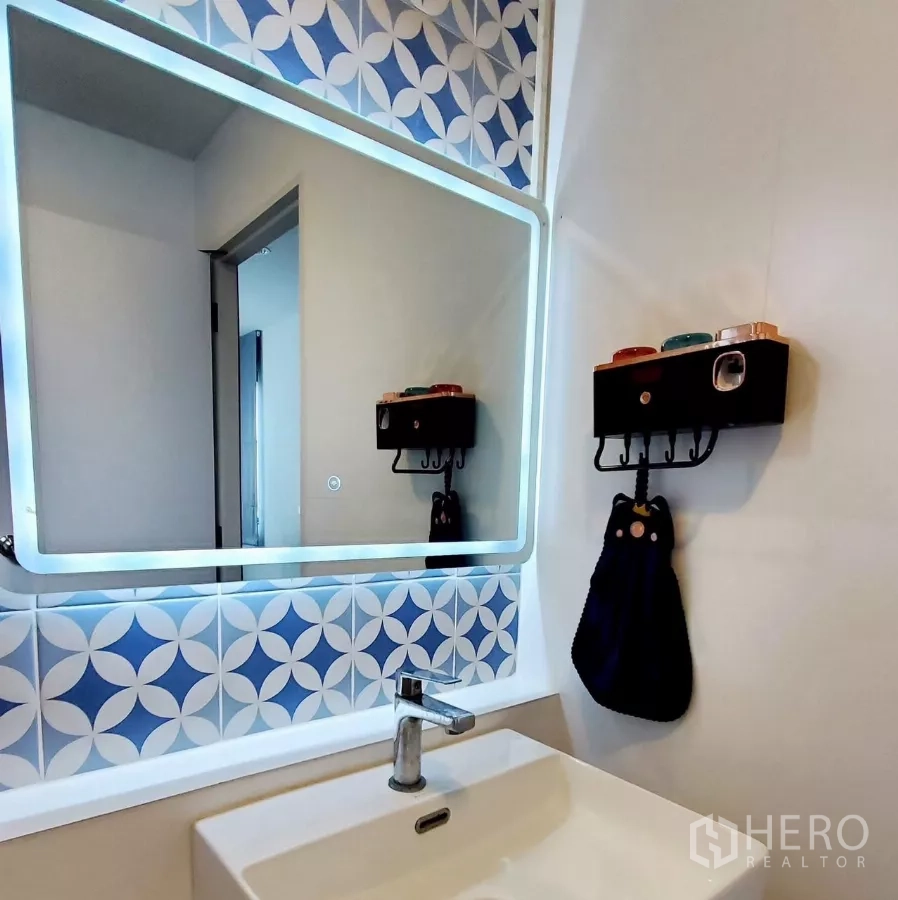 Detached House for rent in Lat Krabang, Bangkok - Close-up of vanity with illuminated mirror and geometric blue tiles.