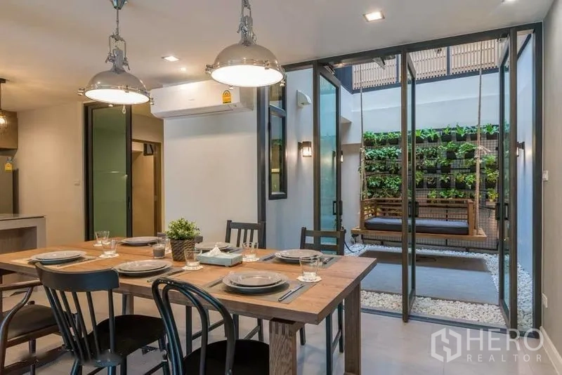 ทาวน์เฮาส์ for rent in Watthana, Bangkok - ห้องทานอาหารเปิดสู่คอร์ทยาร์ดที่มีสวนตั้งฉากและม้านั่งชิงช้า