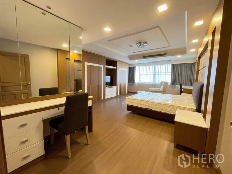 公寓 出租在Watthana, Bangkok - 卧室，带镜梳妆台、内置衣柜与休闲座椅。
