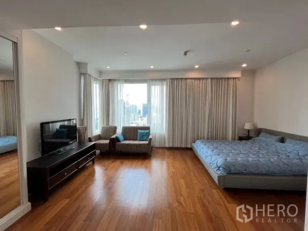 คอนโด ให้เช่าในPathum Wan, Bangkok - ห้องนอนขนาดใหญ่มีมุมนั่งเล่น หน้าต่างเต็มบานและพื้นไม้