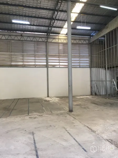 货栈 出租在Suan Luang, Bangkok - 空置仓库分区，混凝土地面，金属百叶通风与中央钢柱，屋顶照明充足。