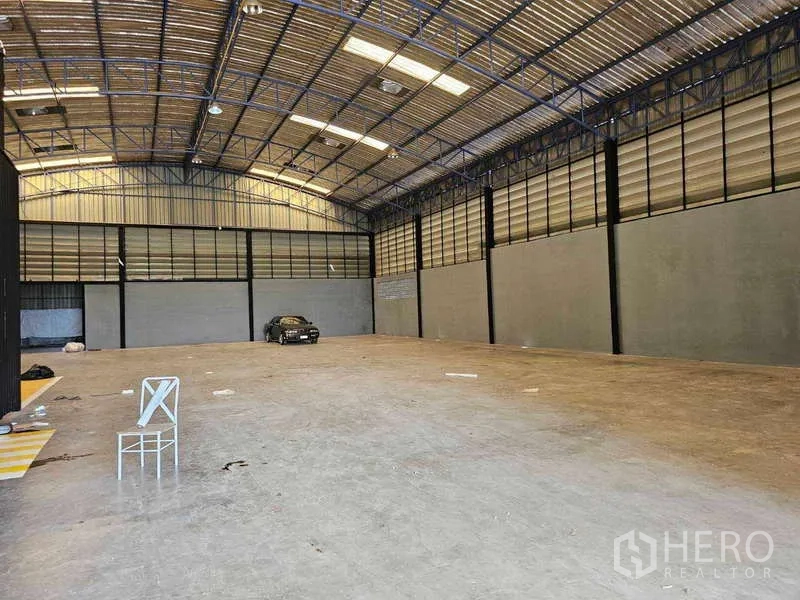 Warehouse for rent or sale in Khlong Toei, Bangkok - Wide open warehouse interior showing high clearance, skylights and smooth loading-friendly floor.