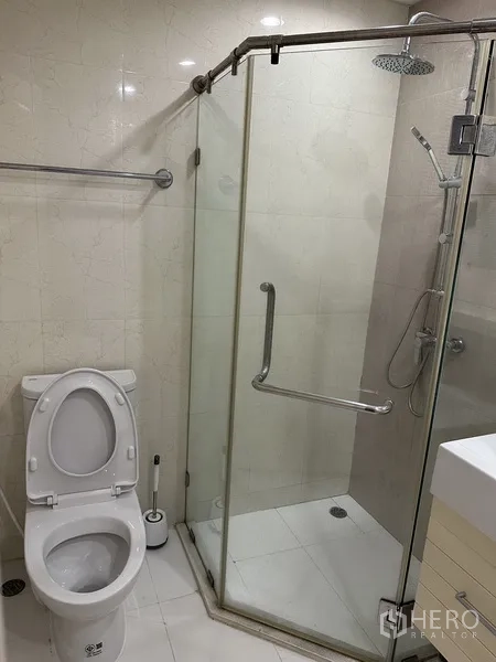 公寓 出租在Watthana, Bangkok - 浴室设玻璃干湿分离雨淋花洒与马桶。