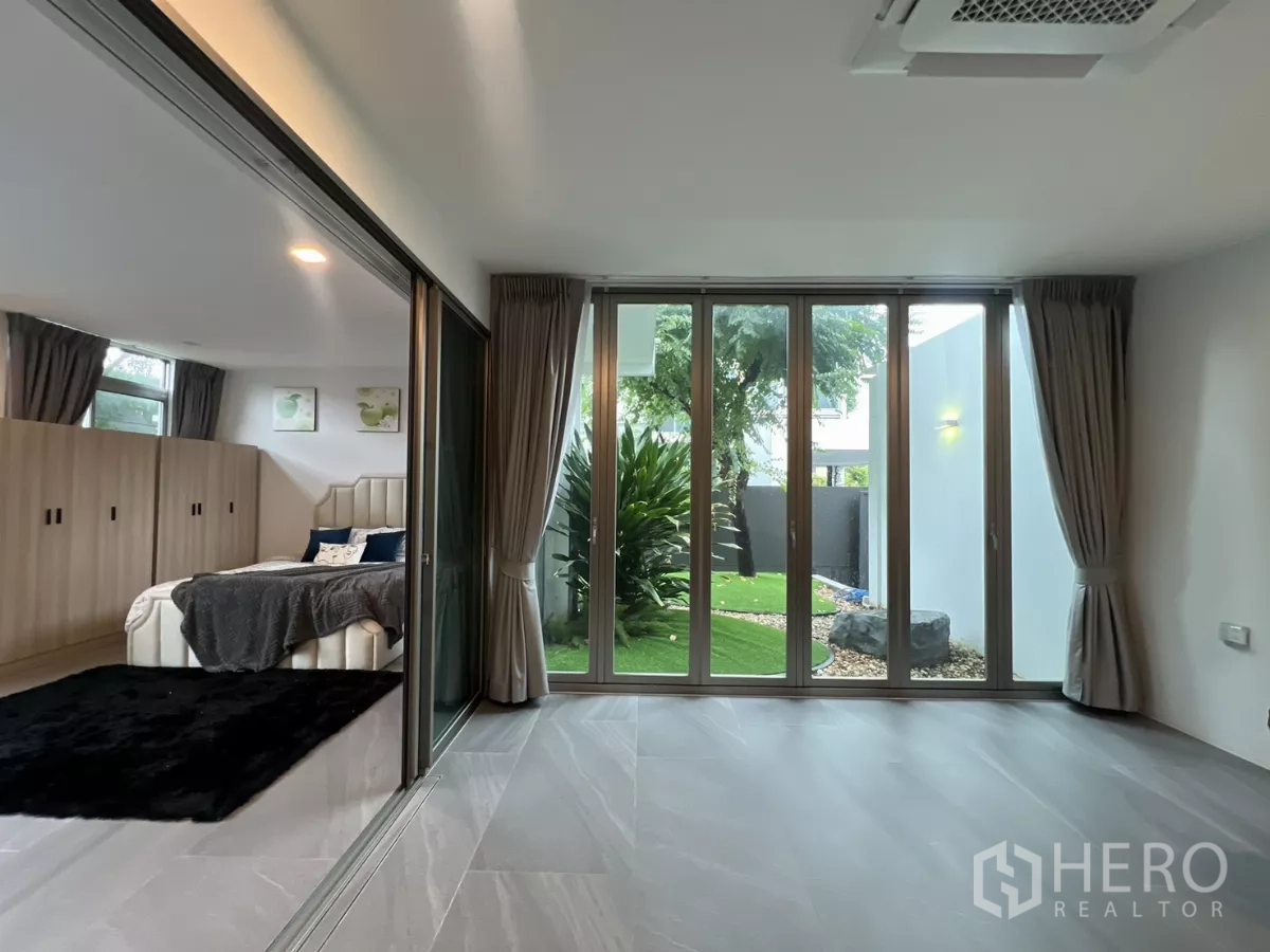 Detached House for rent in Saphan Sung, Bangkok - Ground-floor suite opening to the garden through full-height glass.
