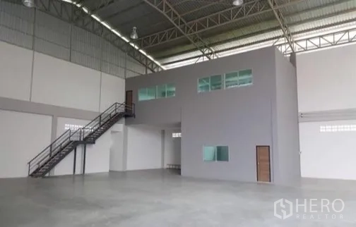 Factory for rent or sale in Bang Sao Thong, Samut Prakan - Warehouse interior featuring enclosed office block and metal staircase.