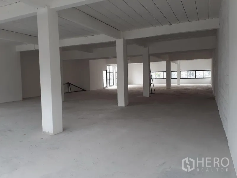 Office Space for rent in Khlong Toei, Bangkok - Unfinished office interior with white columns, ladder, and long strip windows ready for fit‑out.