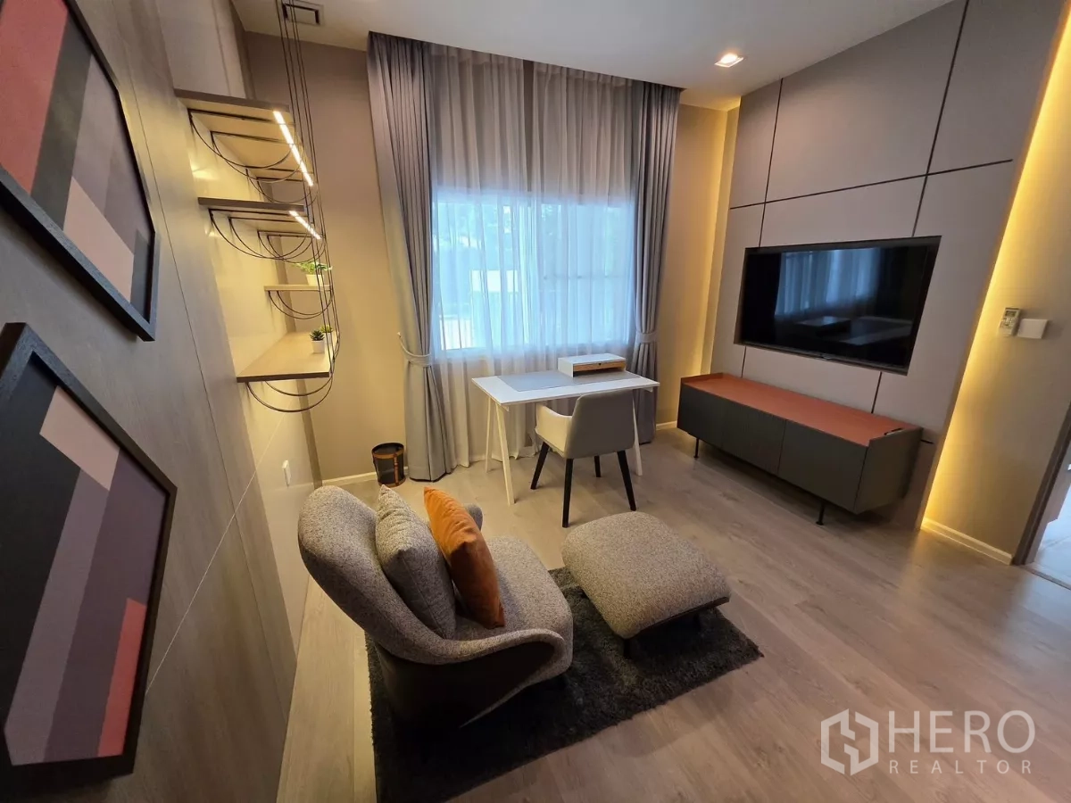 Detached House for rent in Prawet, Bangkok - Cozy family lounge with TV wall, accent lighting and work desk by the window.