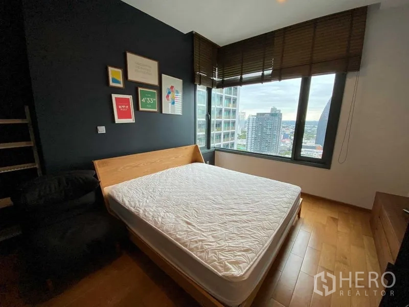 公寓 出租在Khlong Toei, Bangkok - 转角卧室配木床、深色特色墙与大窗，俯瞰城市天际线。