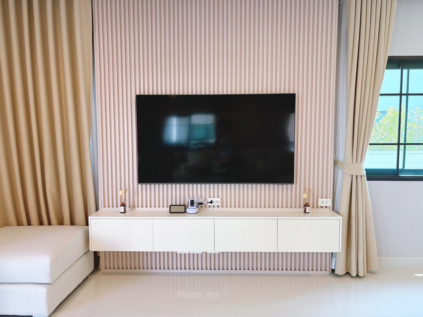 Detached House for rent in Bang Phli, Samut Prakan - Feature wall with mounted flat-screen TV, floating console and full-length curtains.