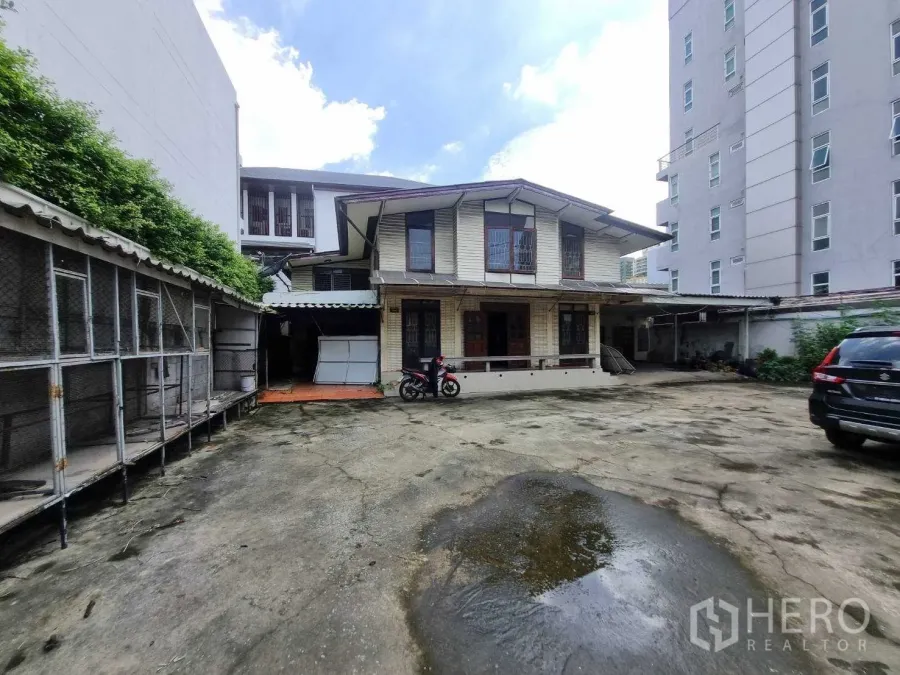 Detached House for rent or sale in Watthana, Bangkok - Two-storey detached house in Thonglor with large concrete courtyard and parking area.