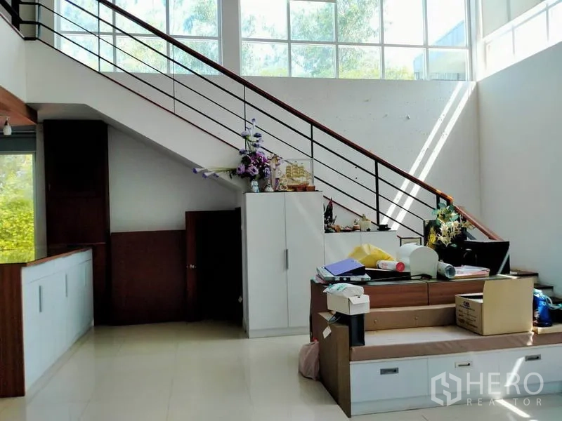 独立式住宅 出售在Thawi Watthana, Bangkok - 金属栏杆楼梯，旁有高窗与收纳柜，采光充裕。