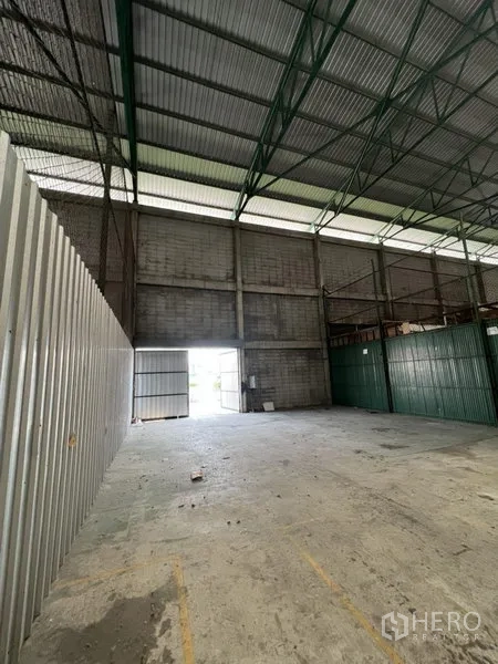 Warehouse for rent in Prawet, Bangkok - Open storage area with metal cladding, natural light and wide door inside Prawet warehouse.