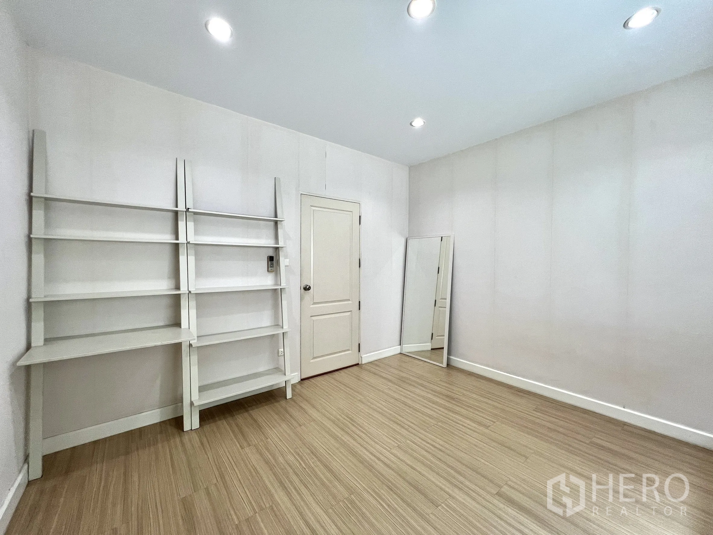 独立式住宅 出租或出售在Saphan Sung, Bangkok - 多功能备用房，白色置物架与木地板，可作家庭办公室。
