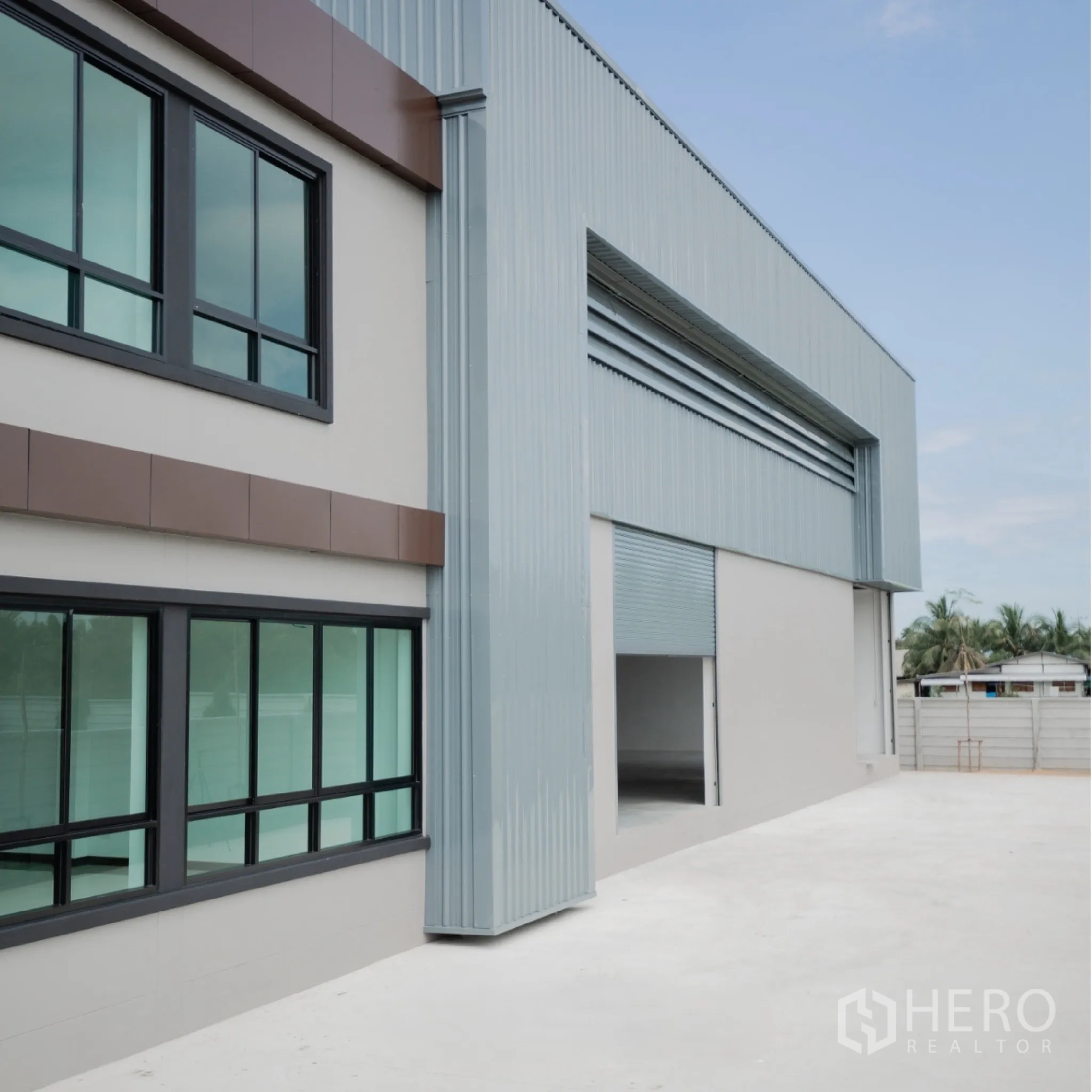 Factory for rent or sale in Bang Len, Nakhon Pathom - Side view of the factory showing a roller shutter door and office windows.