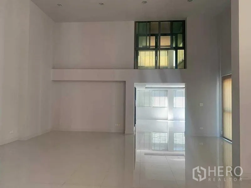 联排别墅 出租或出售在Yan Nawa, Bangkok - 挑高客厅，白色亮面地坪与内窗采光。