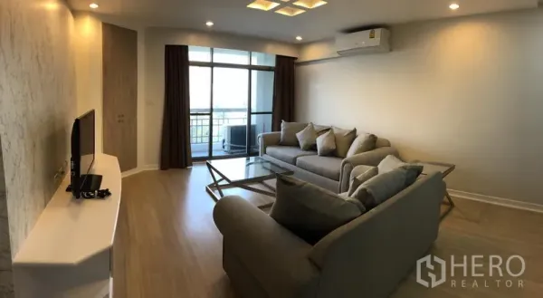 คอนโด ให้เช่าในWatthana, Bangkok - ห้องนั่งเล่นพร้อมชุดโซฟา ชั้นวางทีวี ไฟเพดาน และประตูกระจกเปิดสู่ระเบียง