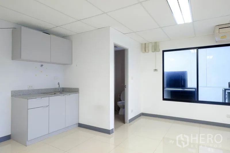 Office Space for rent in Chatuchak, Bangkok - Compact kitchenette next to an internal restroom in a bright office.