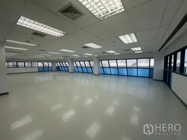 办公空间 出租在Phaya Thai, Bangkok - 大型工作空间，栅格吊顶带空调出风口，连续窗户引入城市景观与自然光。