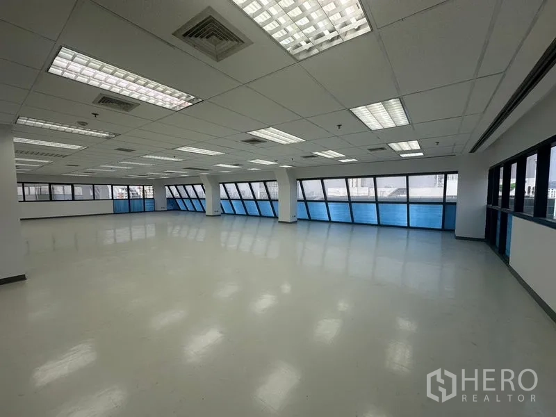 办公空间 出租在Phaya Thai, Bangkok - 大型工作空间，栅格吊顶带空调出风口，连续窗户引入城市景观与自然光。