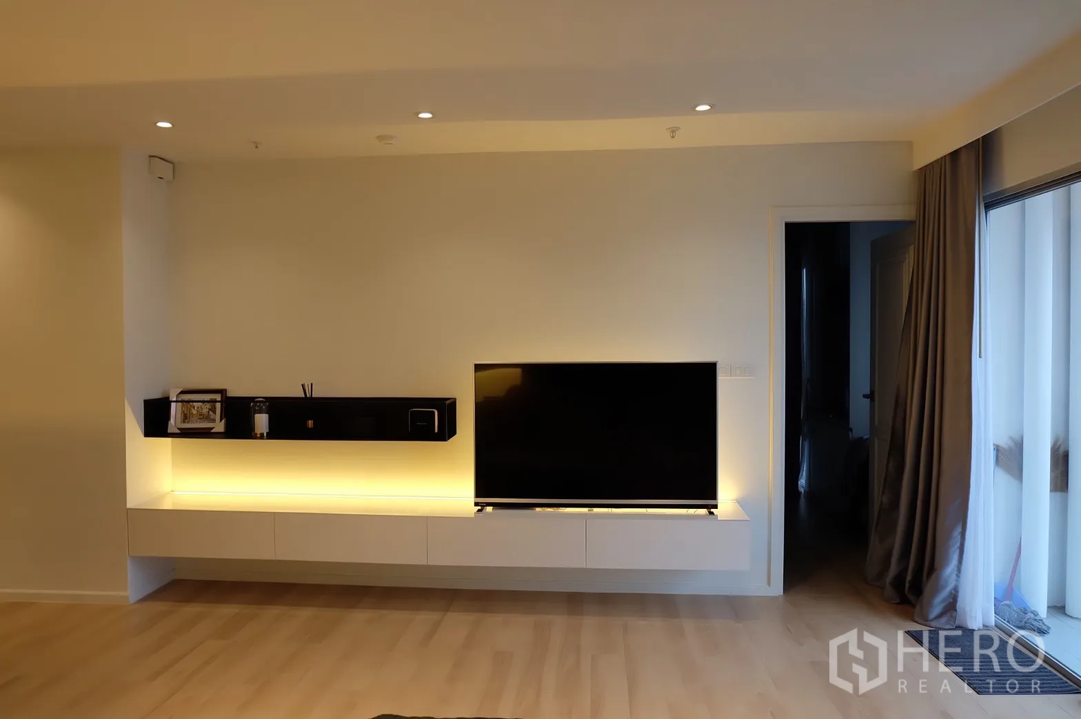 Condominium for rent in Bang Rak, Bangkok - TV console with floating shelf and sliding doors to the balcony.
