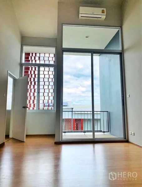 Home Office for rent - Upper room with floor-to-ceiling sliding doors opening to balcony and sky views.