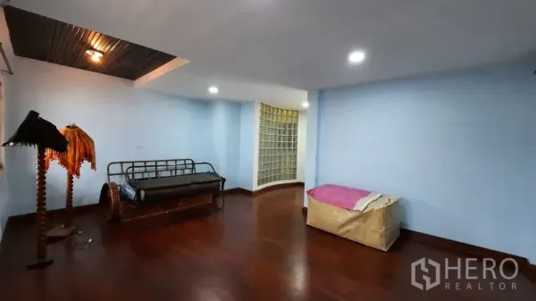 Townhouse for rent or sale in Suan Luang, Bangkok - Spacious living area with polished wood floors and light blue walls.