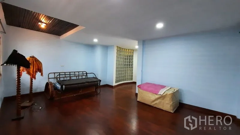 Townhouse for rent or sale in Suan Luang, Bangkok - Spacious living area with polished wood floors and light blue walls.