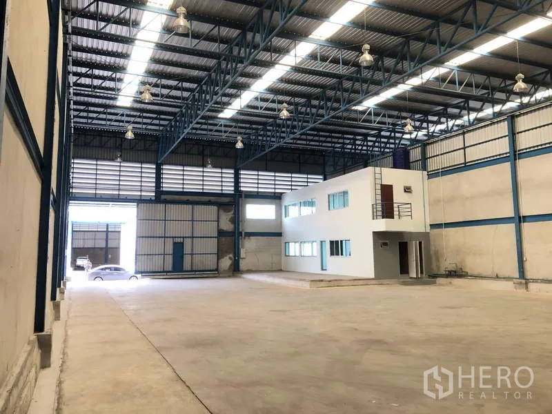 Warehouse for rent in Bang Phli, Samut Prakan - Wide warehouse floor with office unit and loading access at the far end.