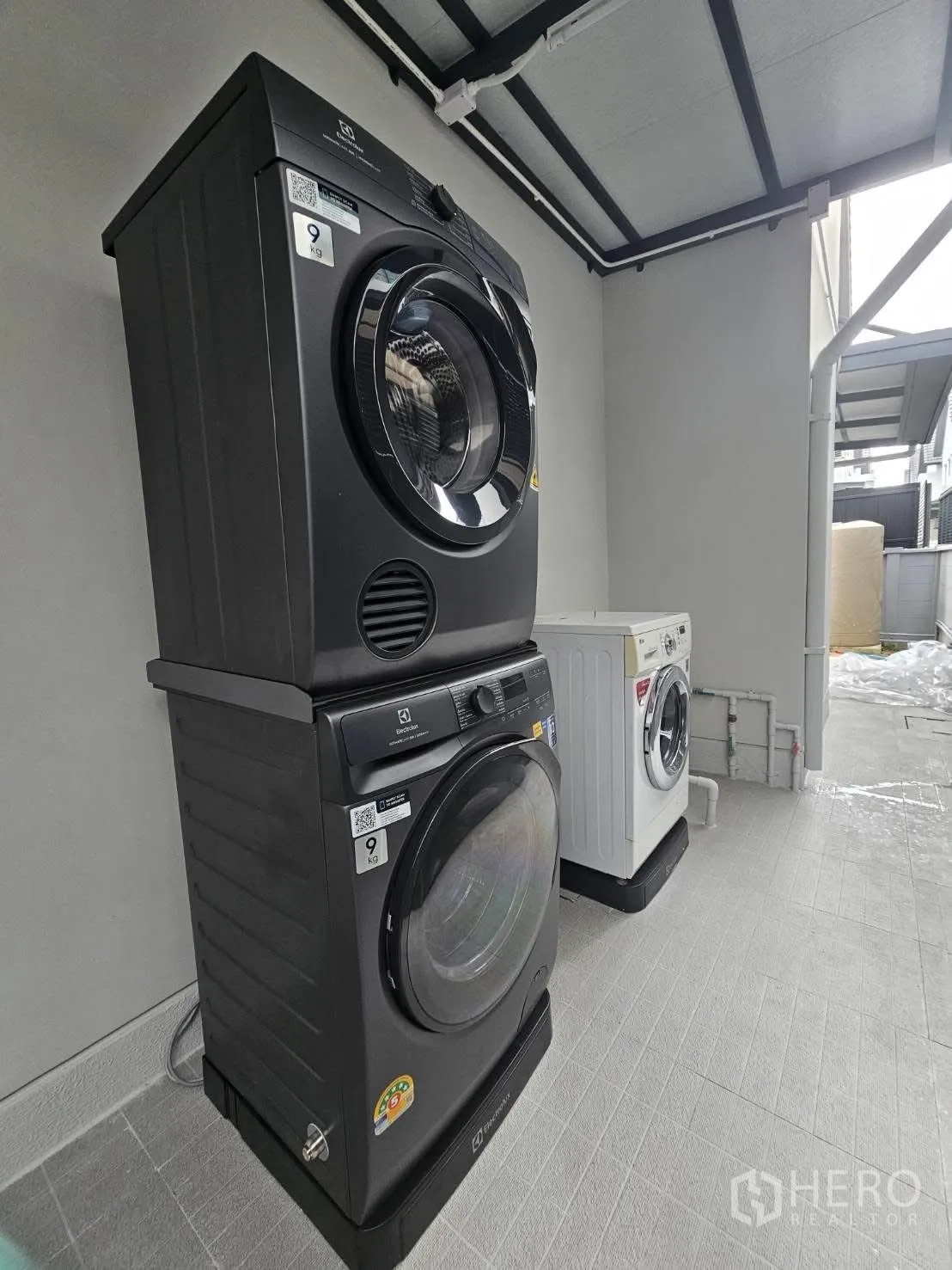 Detached House for rent or sale in Bang Phli, Samut Prakan - Stacked front-load washer and dryer under a roofed utility space.