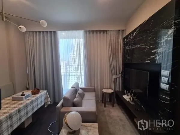 คอนโด ให้เช่าในWatthana, Bangkok - ห้องนั่งเล่นโมเดิร์น ผนังทีวีหินอ่อน โซฟา และผ้าม่านทึบโปร่ง