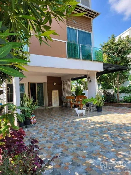 独立式住宅 出租在Lat Krabang, Bangkok - 现代独栋住宅的前庭露台，铺地砖，设有遮蔽休憩区与盆栽。