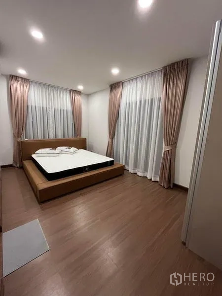 Detached House for rent - Corner bedroom with two large windows, sheer drapes and warm lighting.