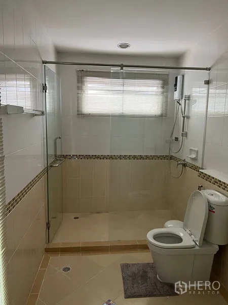 Townhouse for rent in Saphan Sung, Bangkok - Modern bathroom with glass-enclosed walk-in shower, window and white tiles.