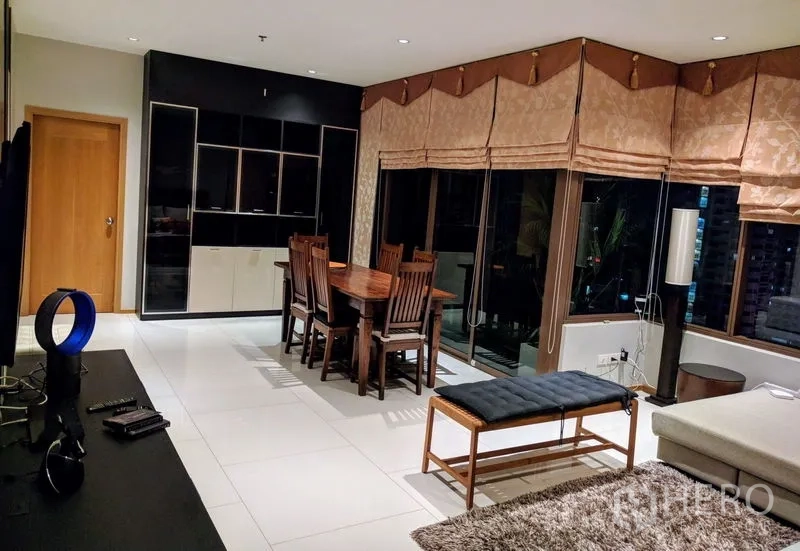 Condominium for rent - Living and dining area showing black display cabinet, six-seat dining table, and glass door to balcony.