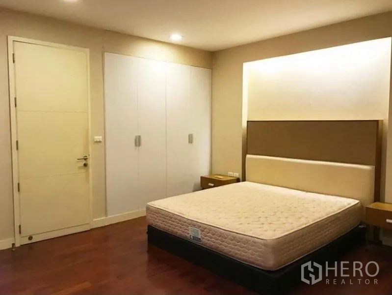 Townhouse for rent in Wang Thonglang, Bangkok - Primary bedroom with built-in wardrobes and warm wood flooring.
