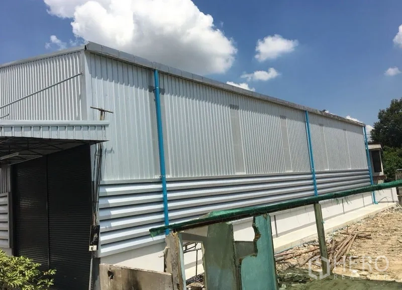 货栈 出租在Din Daeng, Bangkok - 仓库长侧立面，蓝色立柱与排水管