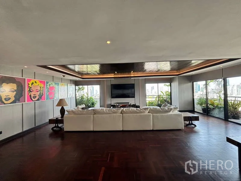 Condominium for rent in Watthana, Bangkok - Expansive living room with white sectional sofa, wood ceiling and city views.