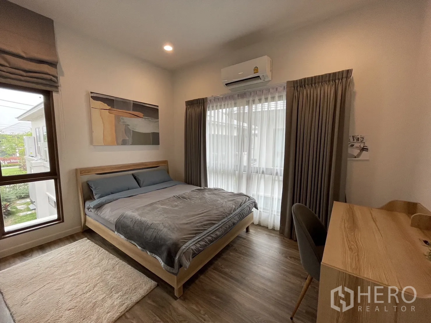 Detached House for rent in Bang Kapi, Bangkok - Secondary bedroom with bed, study desk, and windows with curtains.