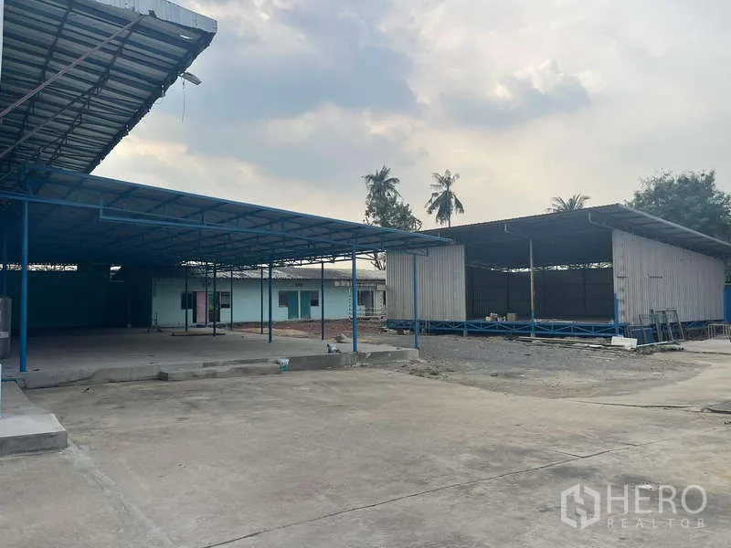Warehouse for rent in Nong Khaem, Bangkok - Open yard with roofed sheds and paved areas for loading and parking.