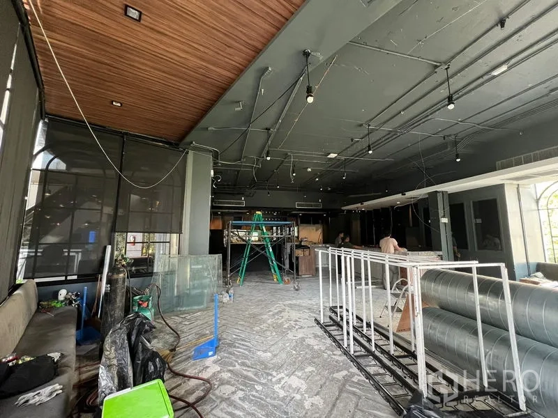 Retail Space for rent - Open trading area with wood soffit, hanging lights and ventilation ducts awaiting fit-out.
