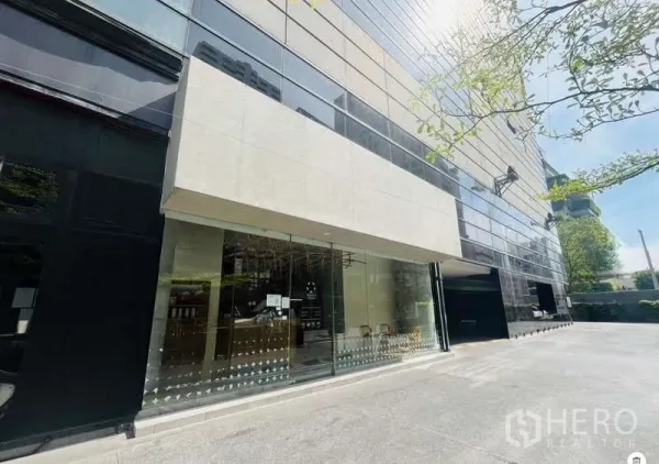 零售空间 出租 - 素坤逸区域现代商业建筑，临街大面积玻璃门面与车道。