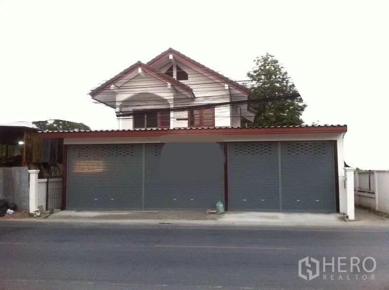 Warehouse for rent in Lam Luk Ka, Pathum Thani - Street-facing warehouse with three metal roller shutters and a gabled upper floor.